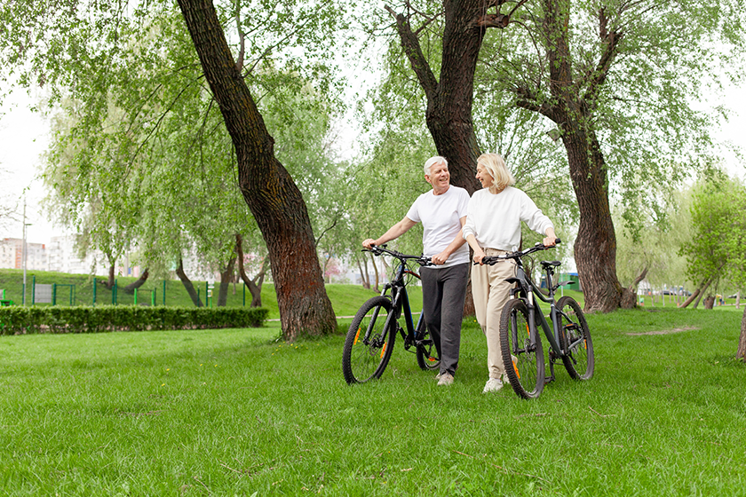 Elderly senior couple rides bicycle in the park