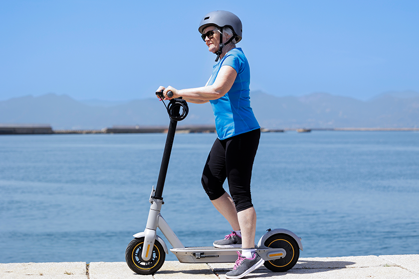 Senior woman with electric scooter on the street 