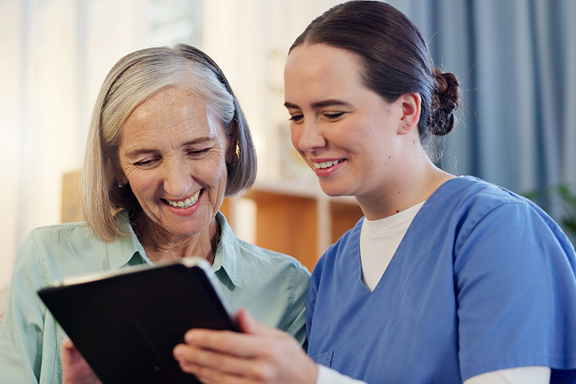 Tablet, nurse and senior woman with smile on couch